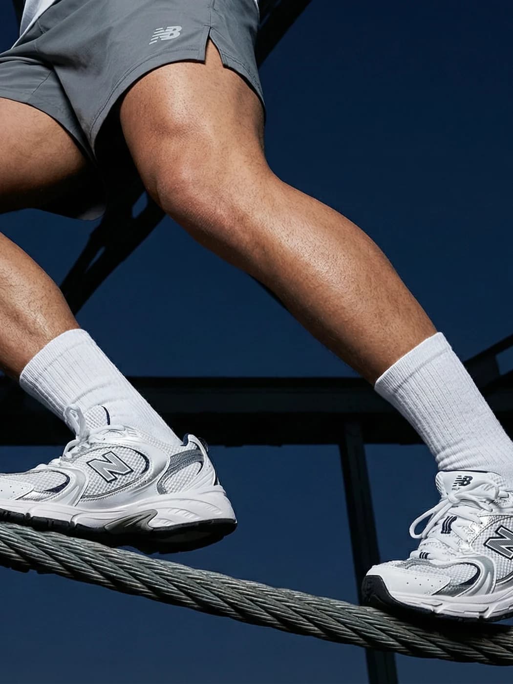 Detalle editorial de zapatillas blancas sobre una estructura metálica